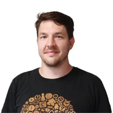 Foto von Michael Zelenka in schwarzen T-Shirt und Brettspiel Symbolen in orange darauf