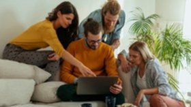 Zwei Pärchen auf Couch mit Laptop