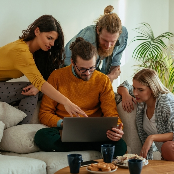 Zwei Pärchen auf Couch mit Laptop