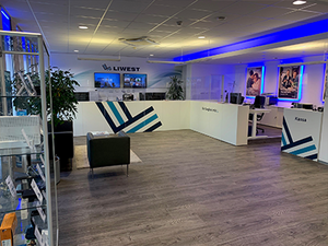 LIWEST Shop Linz. Foto Innenansicht vom Shop. Theke mit LIWEST Logo. Raum blau beleuchtet. LIWEST Shop Linz. Foto Innenansicht vom Shop. Theke mit LIWEST Logo. Raum blau beleuchtet.