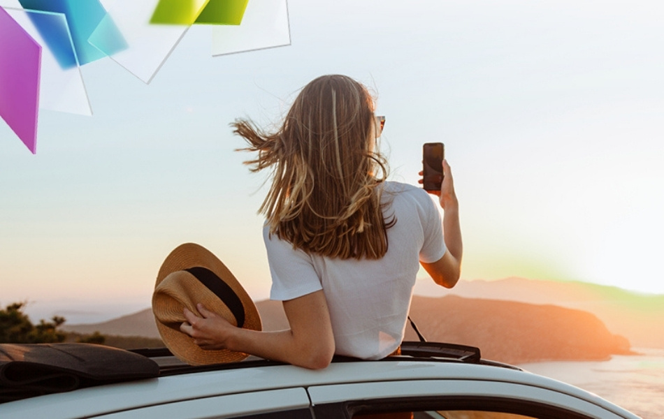 Frau auf Auto Handyfoto Sonnenuntergang am Meer
