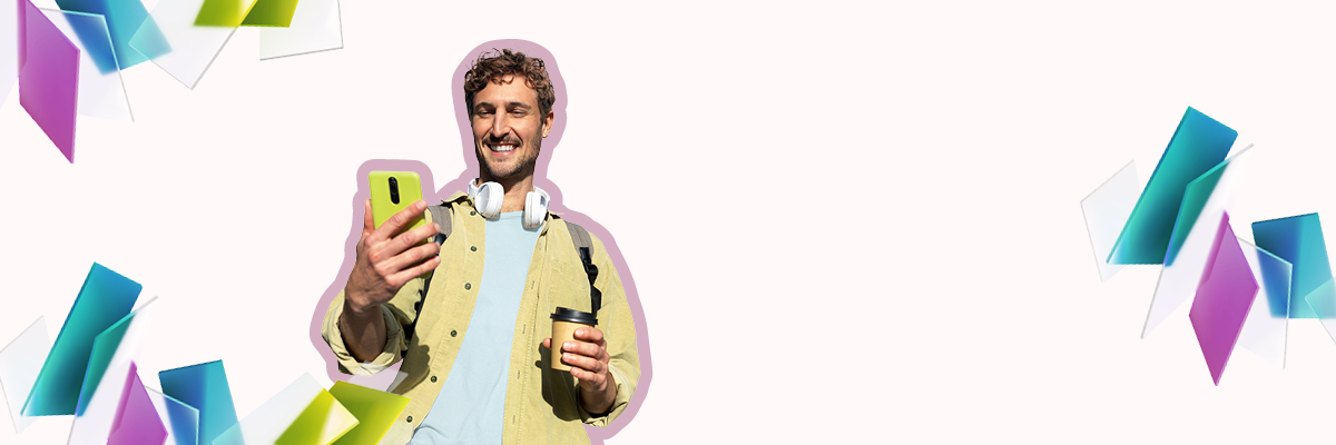 Ein Mann, der in seiner rechten Hand ein Smartphone hält und lächelnd darauf blickt.