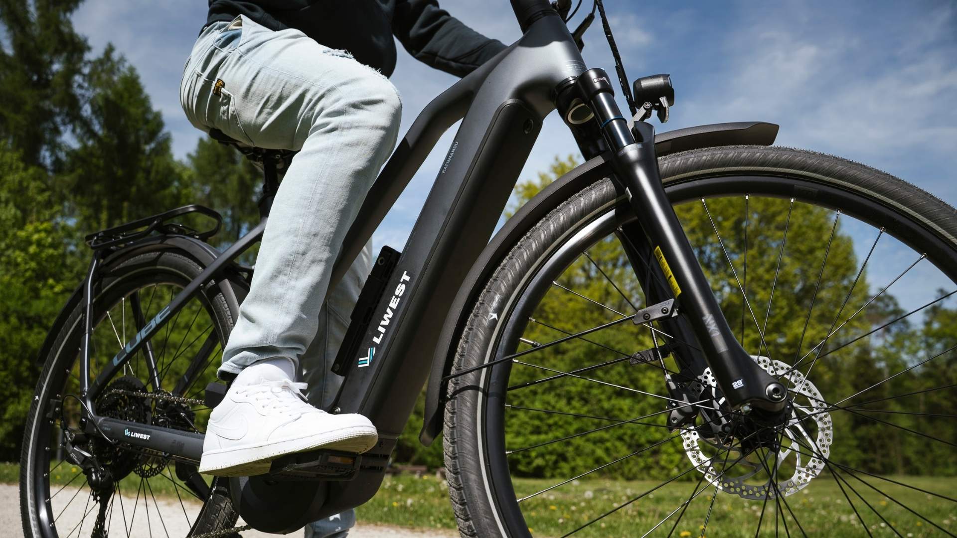 Person auf LIWEST E-Bike in Park beim Losfahren
