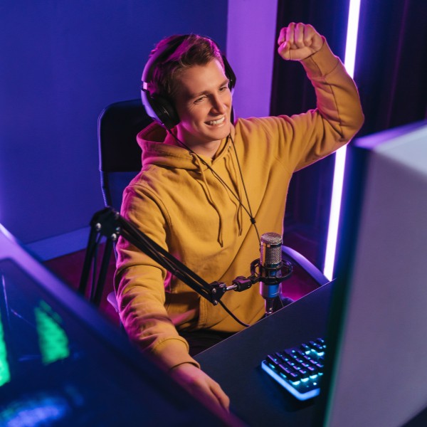 LIWEST Internet Giga 2025 Gamer mit geballter Faust vor PC in Raum mit Neonbeleuchtung