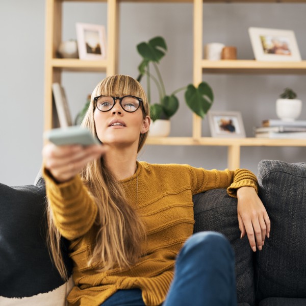 LIWEST Kombi Start 2025 Frau auf Couch mit Fernbedienung in der Hand