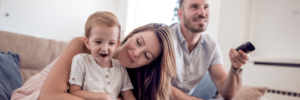 LIWEST Kombi Super 2025 Familie mit Kind, Mutter, Vater und Fernbedienung auf der Couch vor Laptop