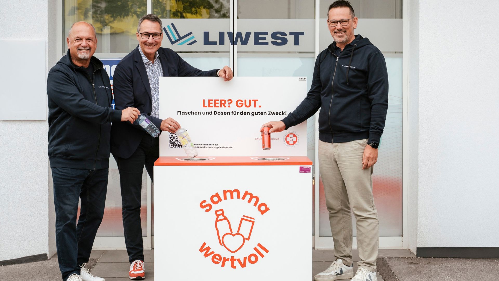 Zwei Herren vom Samariterbund Oberösterreich mit Stefan Gintenreiter vor dem LIWEST Eingang mit der "samma wertvoll" Sammelbox beim Pfandflaschen einwerfen
